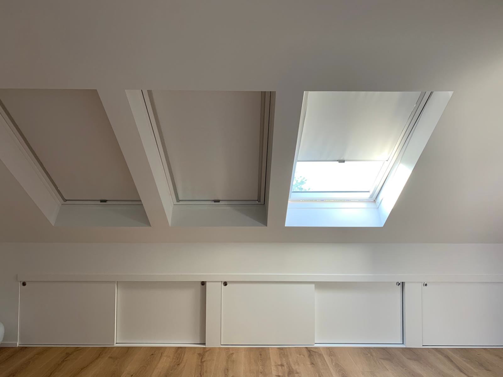 Pièce sous combles, plafond blanc et fenêtres de toit