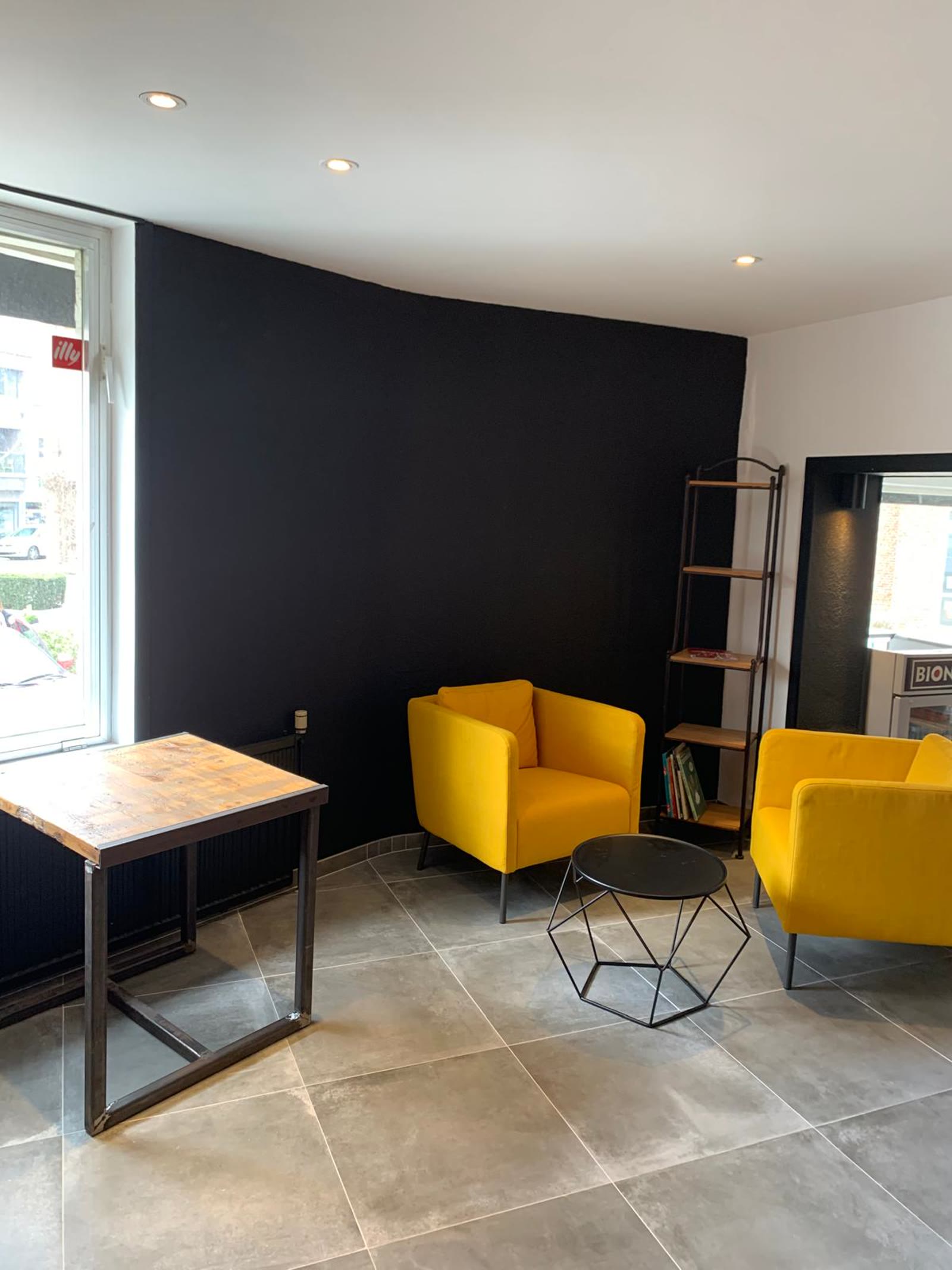 Commerce avec mur noir mat profond et fauteuils jaunes